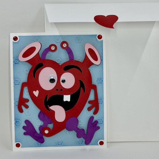 Handmade Valentine's Day card with a colorful cartoonish heart character and a envelope.